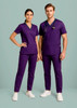 Purple scrub pants featured alongside a matching top, modelled by a woman and a man, both standing against a light background.