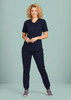 A women's navy scrub top with a zip front and crossover design, paired with matching pants, displayed on a model.