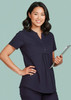 A women's navy tunic scrub top with a relaxed fit, featuring a button-up neckline and a logo on the chest.