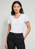 A women's chic top in white, featuring a scoop neckline and short sleeves, worn with tailored black trousers.