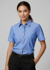 A short-sleeve women's chambray shirt in blue, featuring a collar, buttons, and a chest pocket, displayed on a model.