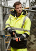 A man's high-visibility waterproof jacket in yellow and black with reflective strips, worn with gloves.