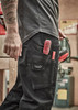 Men's rugged cooling stretch pants in black with multiple pockets and tools visible. The pants feature a logo.