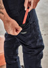Navy cargo pants with a pocket being used to store a red tool. Features a logo on the pocket.