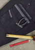 A black work pant featuring multiple pockets, measuring tape, a pencil, and a pair of pliers.