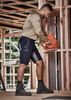 Men's Streetworx Stretch Shorts in navy with grey accents, worn by a man using a nail gun in a construction setting.