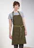 An olive green apron worn by a model, featuring a tie waist and a simple design, with a logo present.