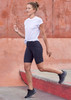 A model wearing black women's Luna bike shorts paired with a white t-shirt and black athletic shoes.