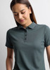 A women's short sleeve polo shirt in dark green, featuring a collared neckline and button placket. It has a logo.