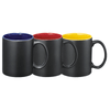 Three ceramic mugs in matte black with contrasting coloured interiors: blue, red, and yellow. Each mug has a handle.