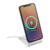 A wireless charging stand in white, holding a smartphone displaying a charging indicator.