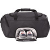 A black duffle bag featuring a separate compartment for shoes, with two pairs of shoes visible. The bag has a logo.
