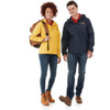A yellow rain jacket on a woman and a navy rain jacket on a man, both featuring logos, standing with a backpack.