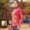 A women's quarter zip jumper in red with a fitted design and a logo on the sleeve.