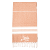 A 100% cotton Turkish towel in a warm orange hue with white stripes and frayed edges, featuring a logo.