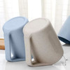 A reusable coffee cup set in light blue and beige, featuring a handle and a textured surface. Contains a logo.