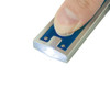 A silver key ring torch with a blue accent, being operated by a finger to illuminate a small area.
