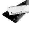 Two plastic rulers, one white and one black, overlapping with measurement markings in both centimetres and inches.