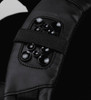 A close-up of a black backpack strap featuring a textured panel with multiple glossy round embellishments.