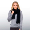 A woman wearing a black 100% Merino scarf, paired with a grey long-sleeve top, model poses with a relaxed look.