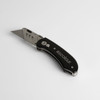 A black utility knife with a metal blade, featuring a logo on the handle.
