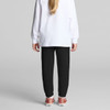Black track pants for kids, featuring a tapered fit and cuffed ankles, paired with a white long-sleeve top.