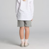 Kids stadium shorts in grey, featuring a simple design. Worn with a long-sleeve white top and patterned socks.