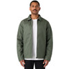 A man wearing a green service jacket over a white t-shirt, standing with a neutral expression. The jacket has a logo.