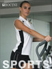 A sleeveless polo shirt in white and black featuring a logo, modelled by a female in a fitness setting.