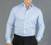 A button-up shirt in light blue with a check pattern and a single chest pocket. Features long sleeves and a collar.