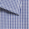 A close-up of a button-up shirt featuring a blue and white gingham pattern. The fabric shows a folded collar.