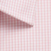 A close-up of a button-up shirt features a light pink and white gingham pattern with a neatly stitched collar.