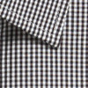 A close-up of a button-up shirt featuring a black and white gingham pattern, with a collared detail and a logo.