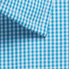 A close-up of a blue and white gingham patterned button-up shirt, featuring a collar and neat stitching.