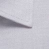 A close-up of a light grey button-up shirt fabric, featuring a textured weave and collar detail.