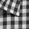 A close-up of a black and white checked button-up shirt, featuring a folded collar and textured fabric.