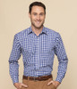 A man wearing a blue and white checked button-up shirt, with a logo on the shirt and a light beige background.