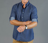 A button-up shirt in navy chambray with rolled sleeves and a subtle pattern. It features a logo on the chest.