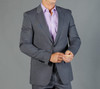 A grey suit jacket is worn over a light purple shirt, featuring a classic lapel design. The model adjusts the cuff.