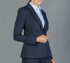 A fitted navy blazer with a structured silhouette, paired with a light blue shirt, featuring a branding logo.