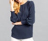 A navy blue top with shirred cuffs and a relaxed fit, featuring long sleeves and a round neckline. It has a brand logo.