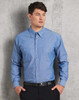 A blue chambray long sleeve shirt with two chest pockets and a button-up front, featuring a subtle brand logo.