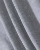 A close-up of light grey fabric, showcasing the soft texture of a fleecy material.