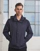 A man wearing a navy versatile jacket, standing with hands in pockets against a backdrop of large windows.