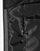 A close-up of a quilted jacket's interior lining in black, featuring a zippered pocket and smooth texture.