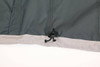 A grey and dark green waterproof performance jacket, featuring a hook detail at the hem. It has a logo.