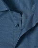 A close-up of a navy blue men's button-up shirt featuring a pin dot pattern and blue buttons.