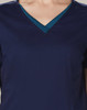 A navy scrub top featuring a contrasting teal V-neck collar and short sleeves. It has a logo on the front.