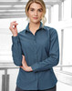 A teal button-up shirt for women with a pin dot pattern and long sleeves, featuring a logo on the chest.