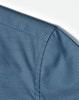 A close-up of a blue pin dot pattern on a 3/4 sleeve shirt, featuring a button-up design.
